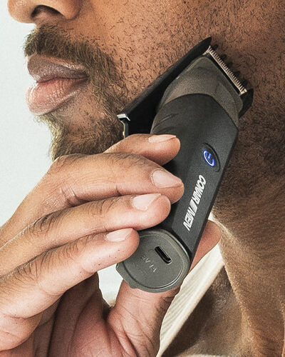 man using trimmer on beard
